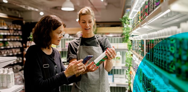 A store worker helping a woman choose a product