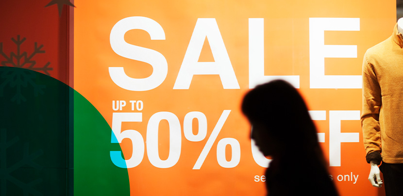 A woman walking past a sale sign